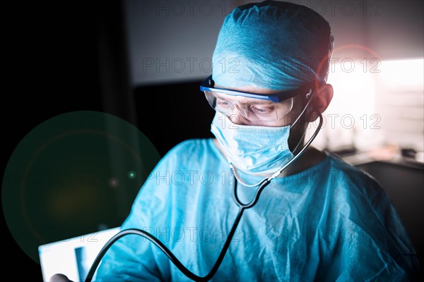 Doctor male surgeon in uniform working with a stethoscope in a medical office