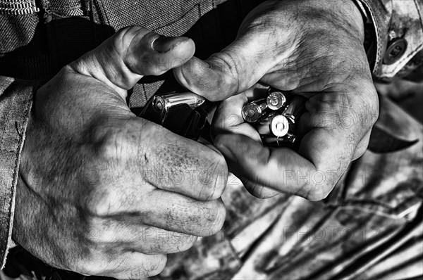 The fighter prepares a clip with bullets before the next fight.