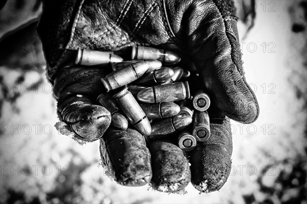 The fighter holds a handful of bullets in his palm for weapons.