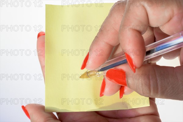 Woman's hand with painted nails holding blank letter paper on pure white background