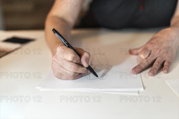 Close-up of a fashion desinger drawing with a pencil