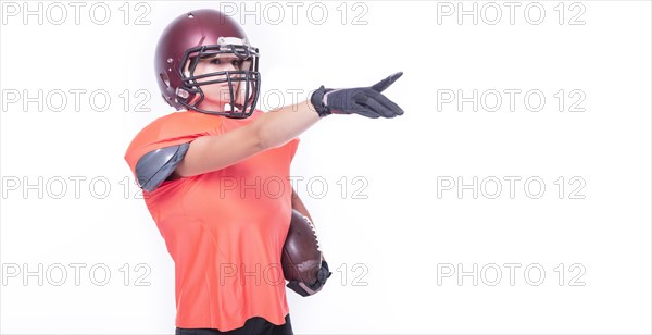 Woman in the uniform of an American football team player points with a finger to the empty space. Sports concept.