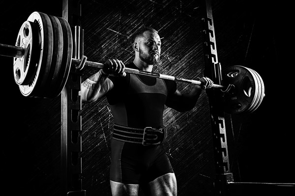 Professional athlete prepares to squat with a barbell.