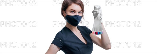 Portrait of an elegant beautiful girl wearing a protective mask with a set of nail palette in hand. White background. Advertising banner for beauty salons during Covid-19. Pandemic. Modern trends.