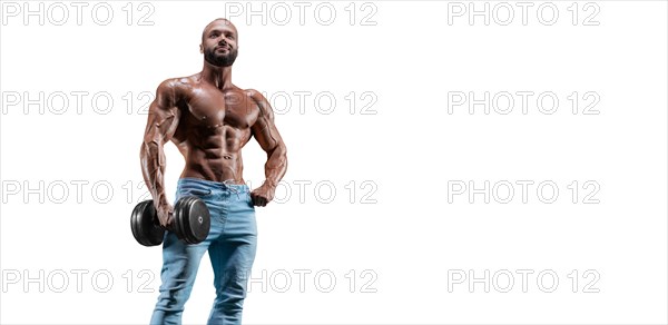 Sportsman posing on a white background in jeans with a dumbbell in his hand. Fitness