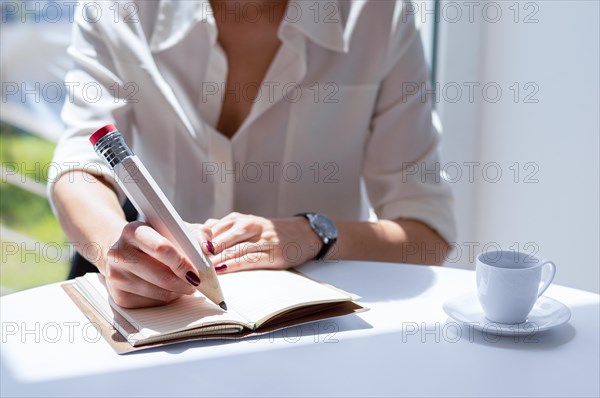 The girl writes in a notebook with a large pencil. Concept of job interview