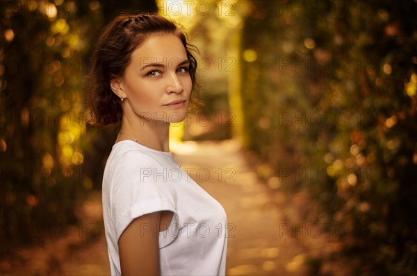 Portrait of a charming girl in the Mystic Sunny Alley in Boboli Gardens.