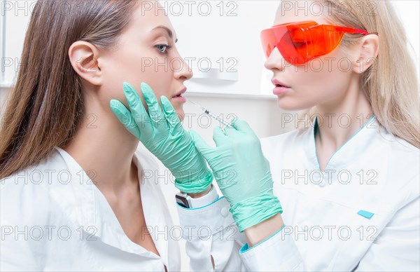 Portrait of two girls in white coats. The concept of cosmetology