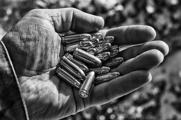 The fighter holds a handful of bullets in his palm for weapons.