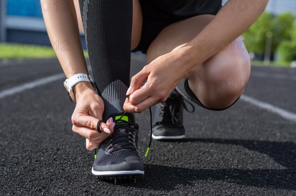 Image of lacing athletic shoes on a stadium track. Running concept.