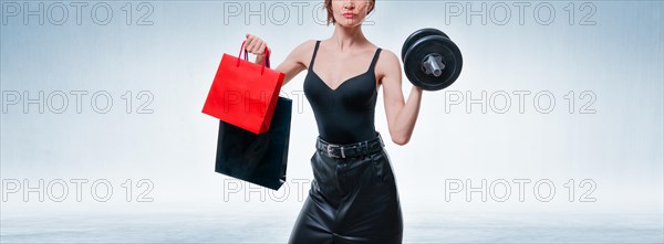 No name woman portrait with dumbbell and gift bags. Gift concept. Gym membership.