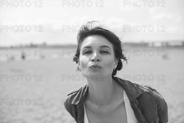 Portrait of a woman sending a kiss to the camera. Windy weather. Happiness