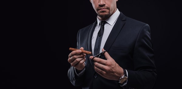 Image of an adult stylish man in a suit with a cigar. Cigar clubs concept.