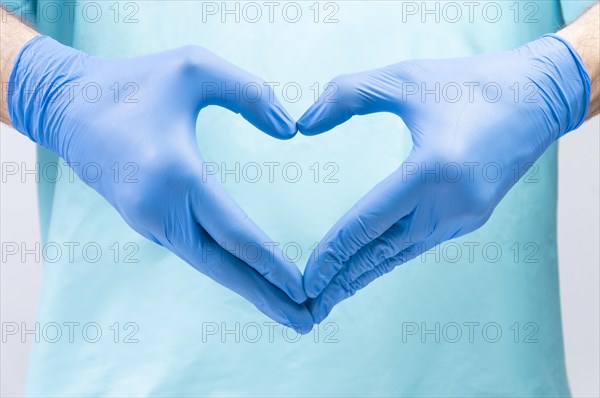 The doctor folded his hands in the shape of a heart. Medical concept.