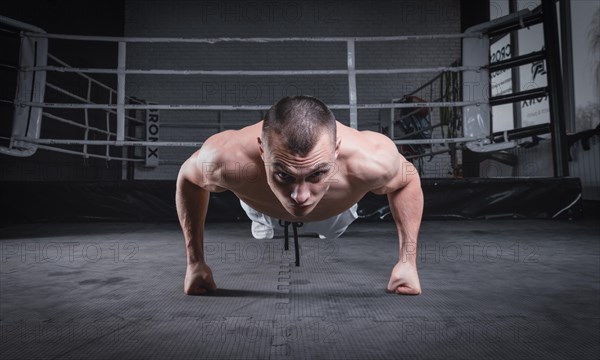 Muscular man doing push-ups in the gym. Fitness concept.