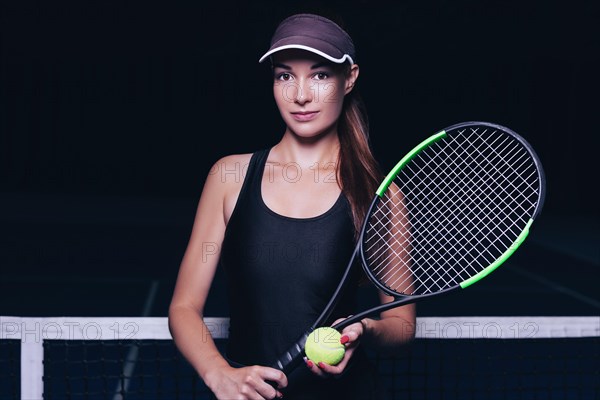 Portrait of a beautiful tennis player posing on the court. Sports concept.