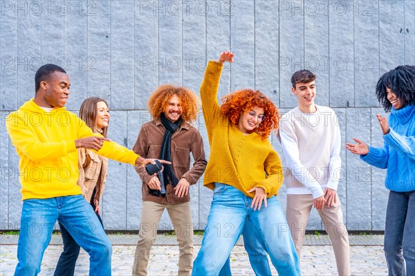 Diverse and multi-ethnic friends celebrating and dancing in the street