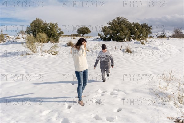Child and mother having fun in snowy landscape