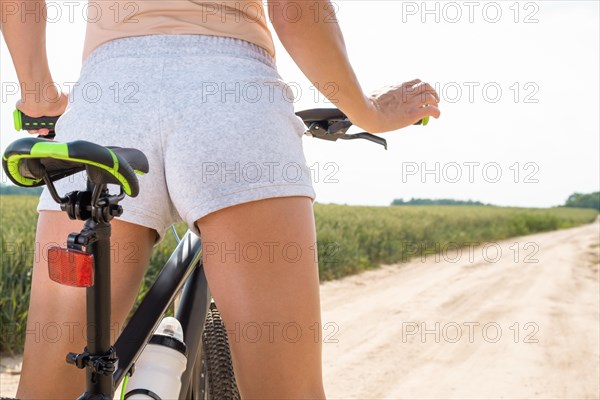 Impersonal portrait of a woman on a bicycle. Back view. Recreation and tourism concept.