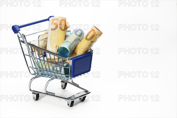 Shopping cart full of rolled up euro banknotes