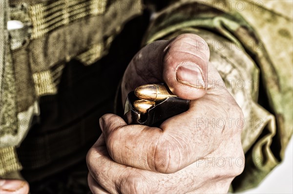 The fighter prepares a clip with bullets before the next fight.