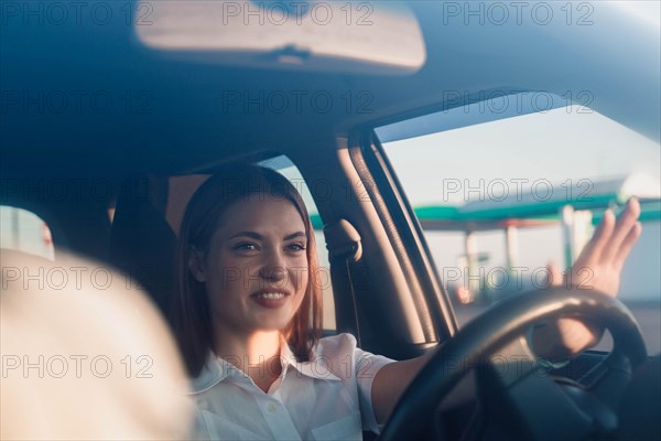 Young beautiful girl taxi driver smiling behind the wheel