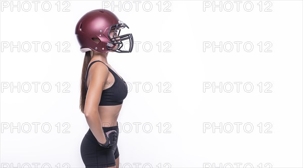 Woman in the uniform of an American football team player posing on a white background. Sports concept.