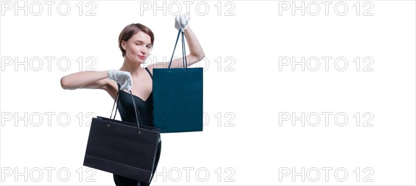 Stylish tall girl in white gloves demonstrates a black luxury package. The concept of safe shopping during a pandemic