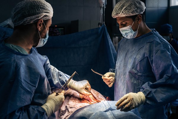 Doctors stitching a patient's back after surgery. Surgical procedure for scoliosis