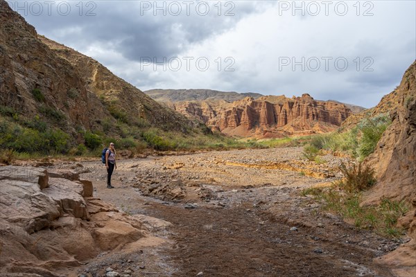 Climber in a canyon with a dry stream bed