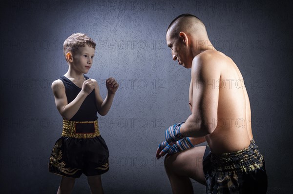 Kickboxing coach is training the boy. The concept of family