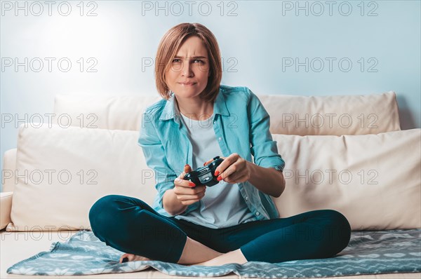 Girl with a joystick in her hands enthusiastically plays a computer game. ESports concept.