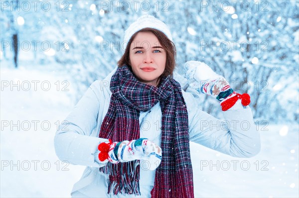 Portrait of a beautiful girl throwing a snowball. Concept for Christmas holidays