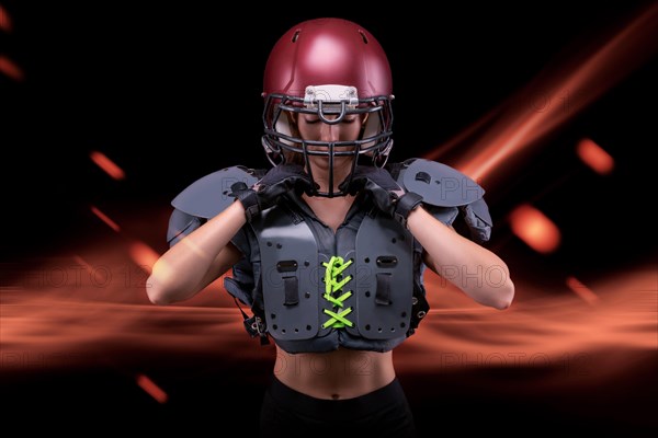 Brutal portrait of a girl in the uniform of an American football team player. Equipment advertising. Sports concept. Shoulder pads.