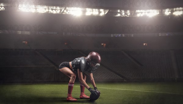 Image of a girl in the uniform of an American football team player preparing to play the ball at the stadium. Sports concept.