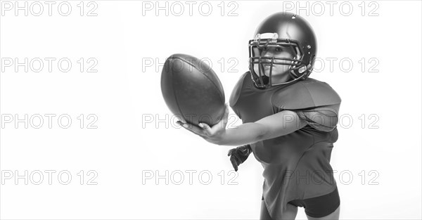 Black and white images of a sports girl in the uniform of an American football team player. Sports concept. White background.