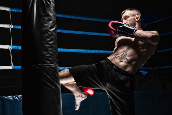 Kickboxer hits the bag with his knee. Training a professional athlete. The concept of mma