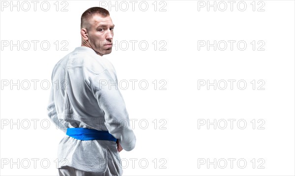 Strong man in a kimono looks over his shoulder. Concept of karate