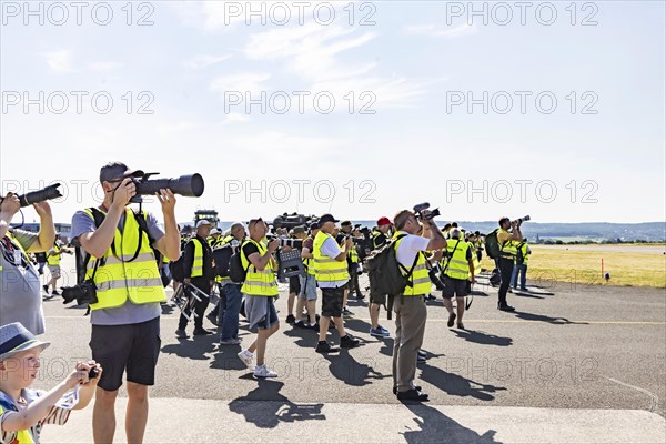 Photographers watch an air show