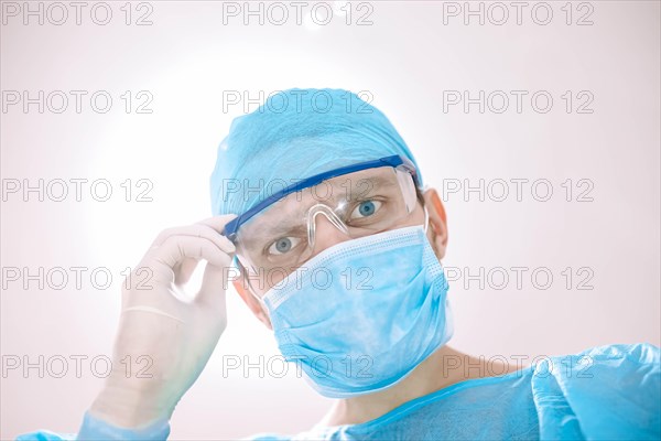 Male surgeon doctor in the operating room looking at the patient at the camera