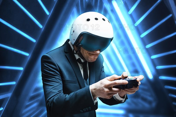 Portrait of a man in a suit and helmet of a pilot with a joystick in his hands. He enthusiastically plays a computer game. Game space. Game concept.