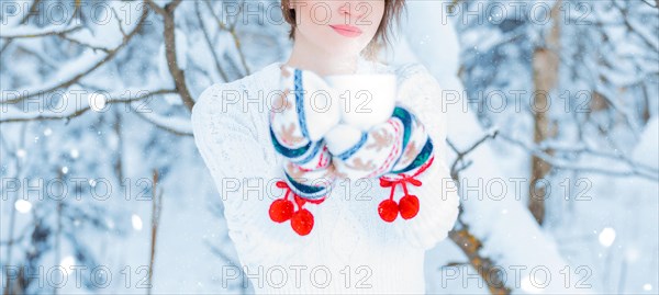 No name portrait of a girl on the background of a frosty winter morning with a cup in her hands. Winter vacation
