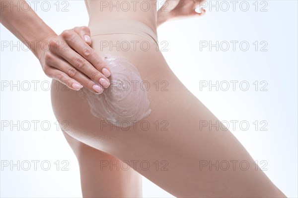 Image of female hands applying cream to the buttocks. Medical concept. Anti-cellulite ointments.