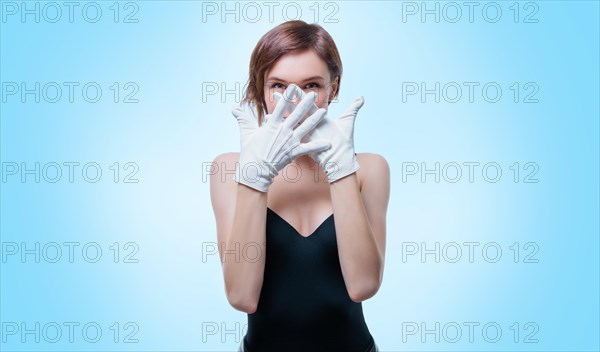 Confused girl in white gloves posing in the studio on a white background. No name portrait