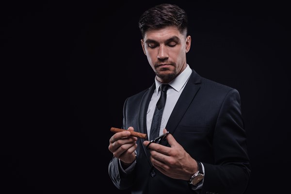 Portrait of a stylish man in a suit with a cigar. Business concept.