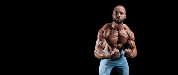 Isolated muscular man on a black background. Bodybuilding and fitness concept. Panorama.