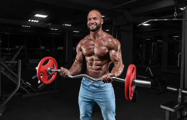 The athlete is doing a workout in the gym with a barbell. Fitness