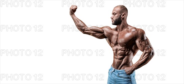 Sportsman posing on a white background in jeans. Fitness