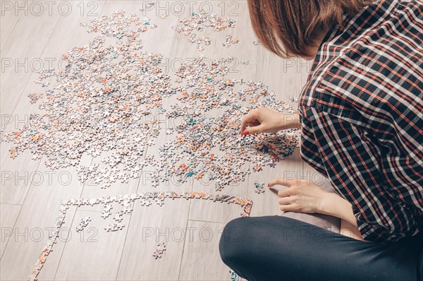 Teenager plays puzzles. The concept of board educational games. Stay at home.