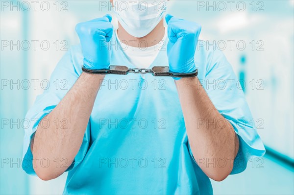Portrait of a doctor in handcuffs. The concept of corruption in medicine.